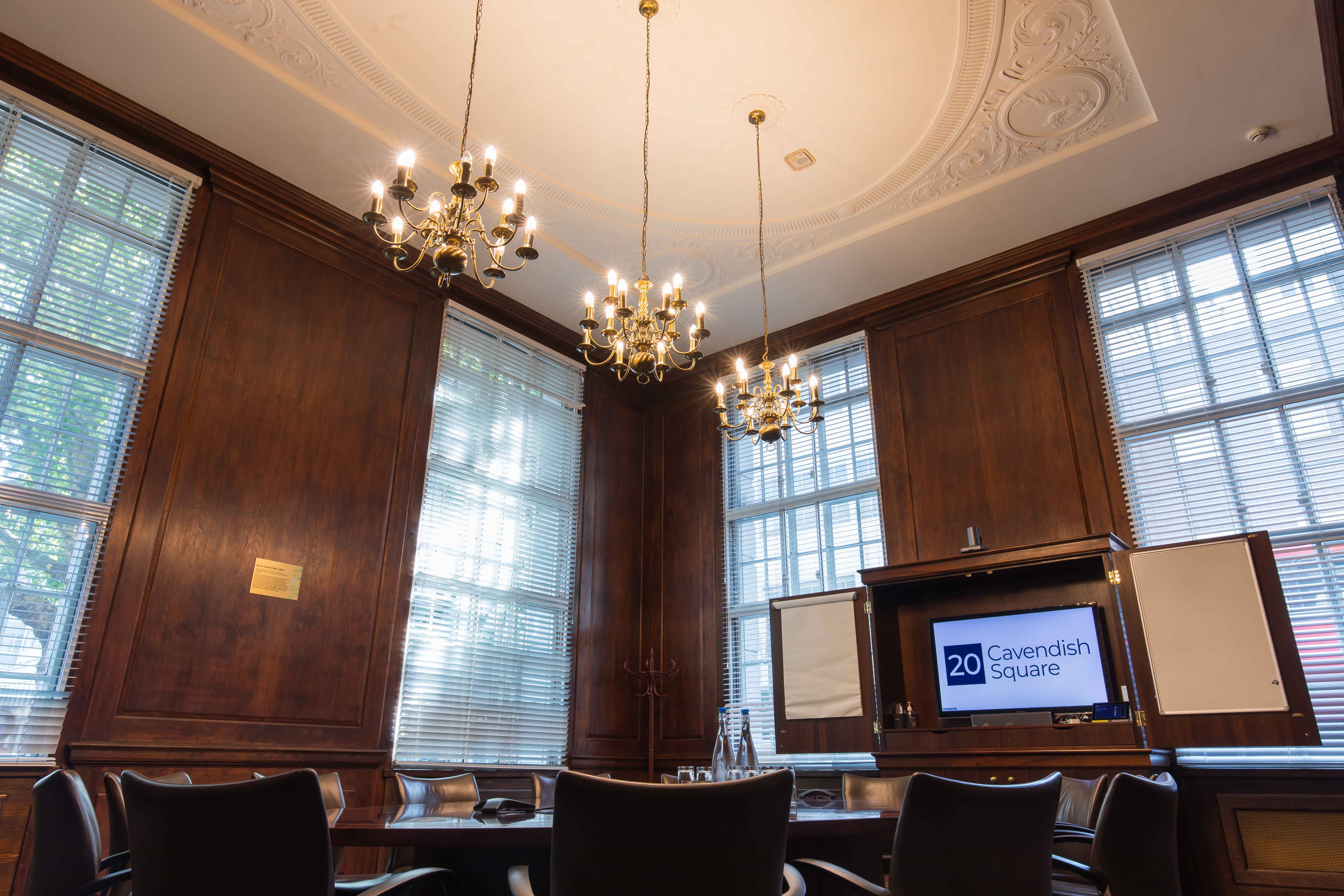 Sarah Swift in elegant meeting room with chandeliers for corporate events.