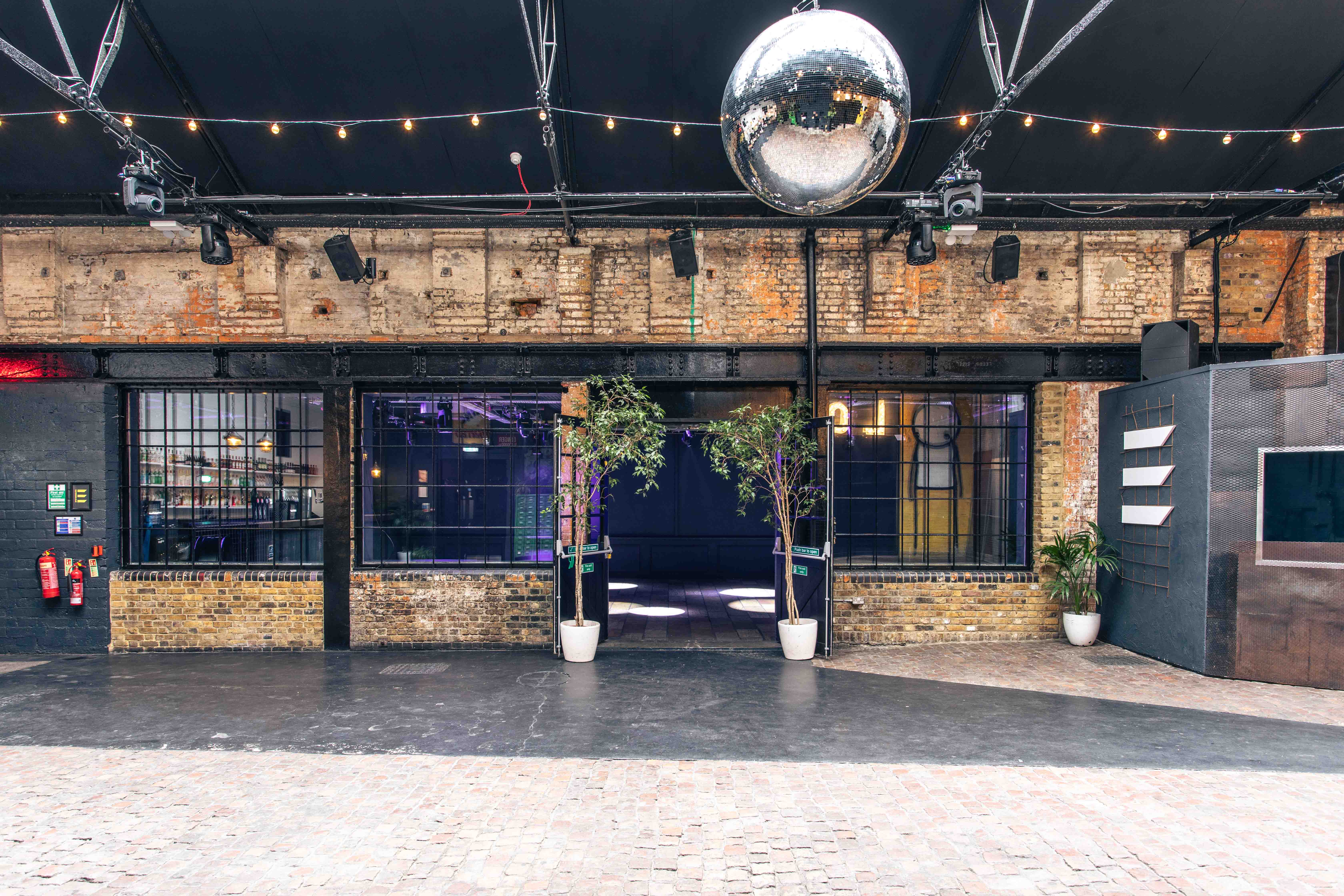 Versatile industrial event space with disco ball for corporate and social gatherings.