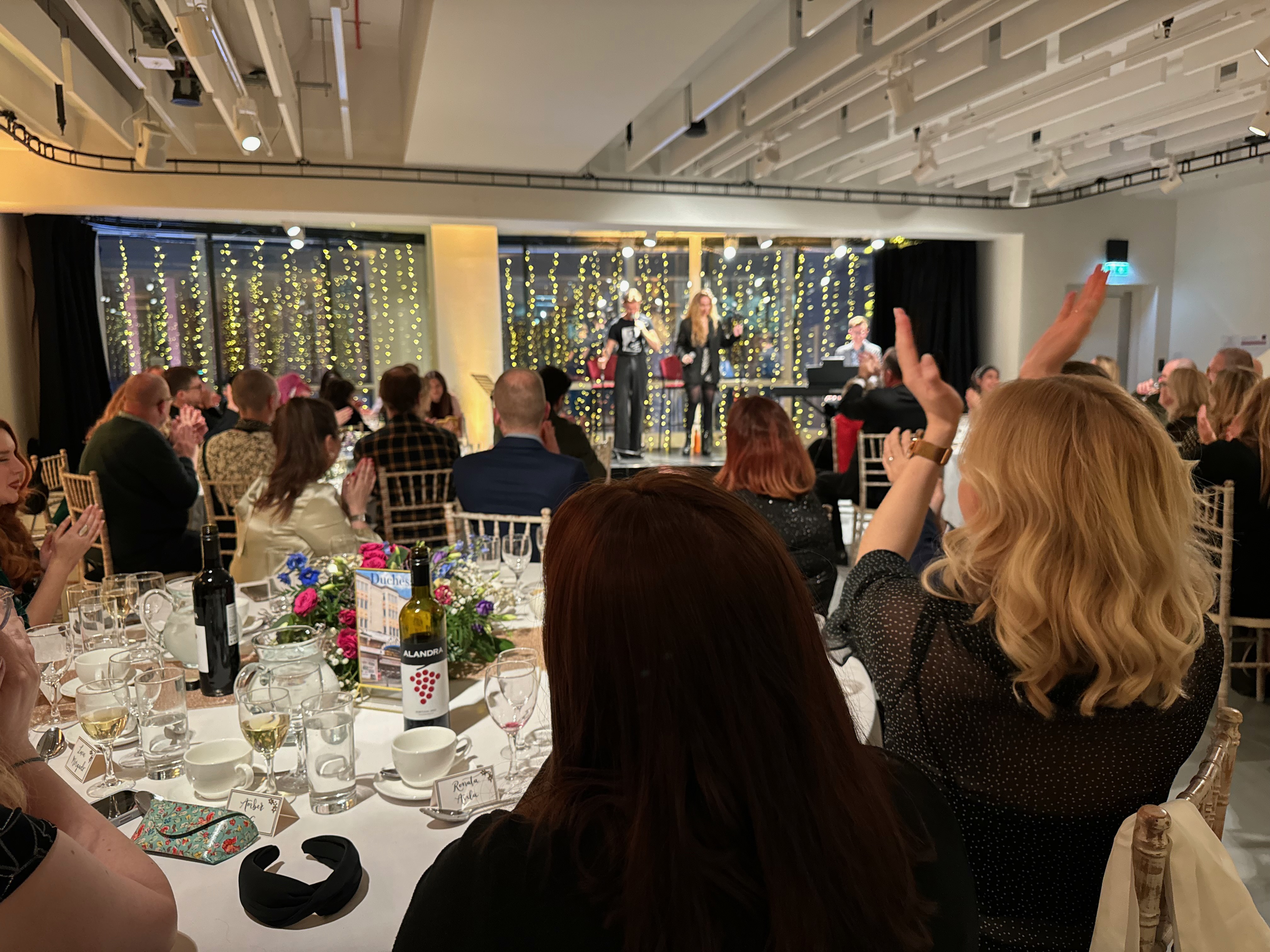 Lively event at Nica's Bar, elegant decor and engaging speaker, perfect for corporate gatherings.