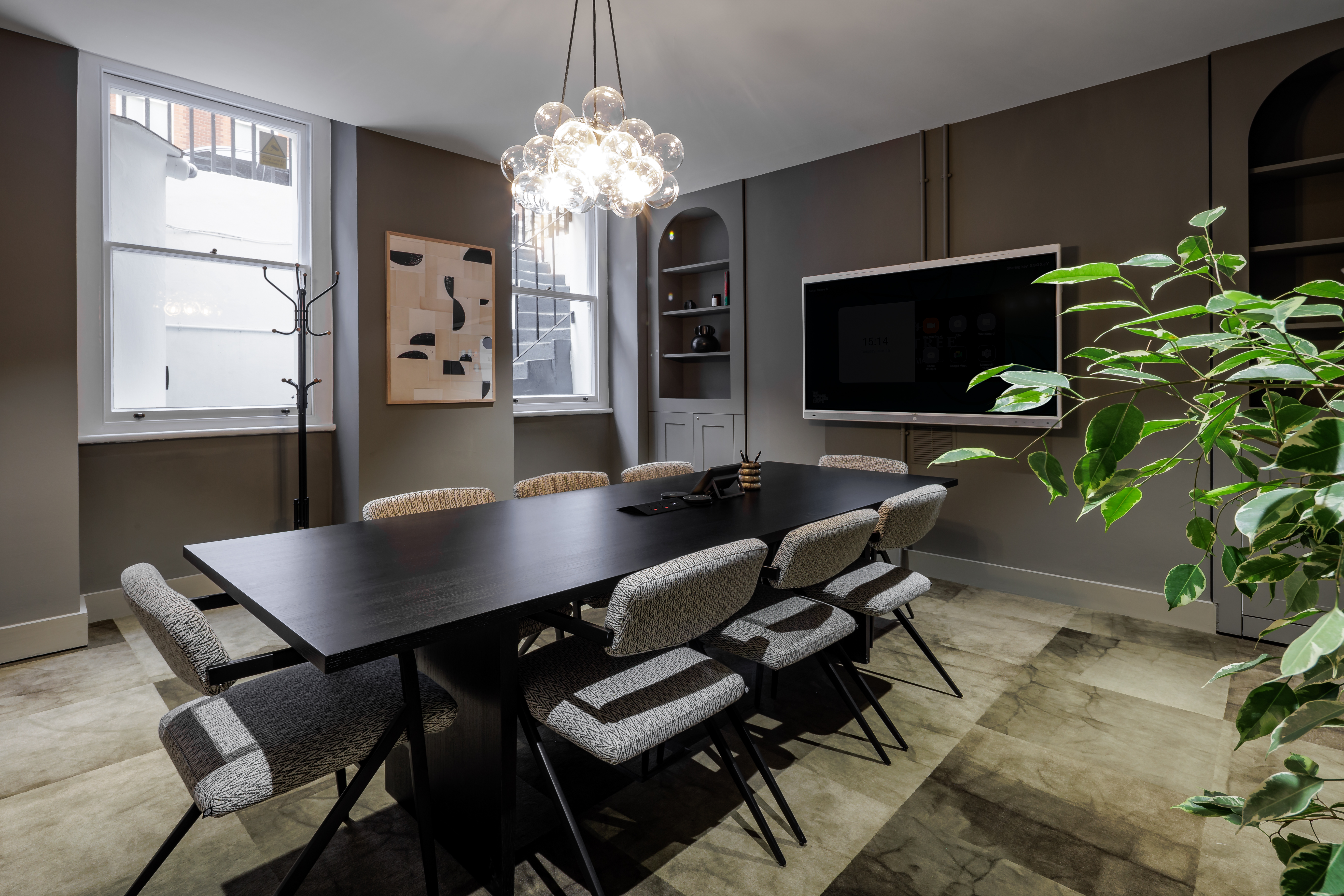 Modern meeting room with elongated table and ample natural light - ideal for conferences.