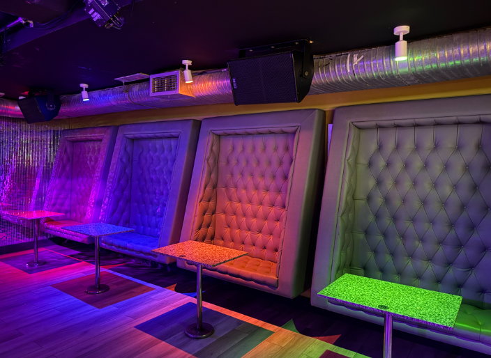Nightclub-style venue for event hire with industrial lighting and plush booths.