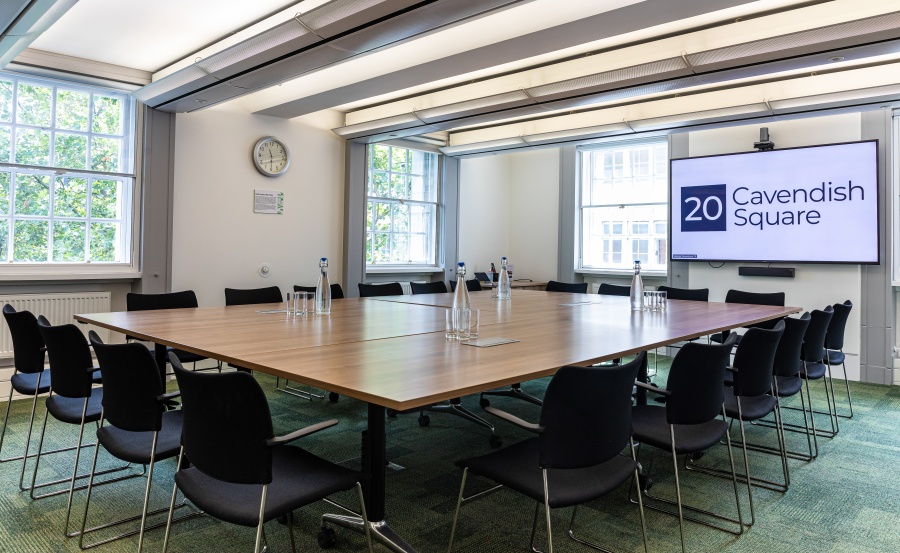 Meeting room with large table and natural light, perfect for brainstorming or strategy sessions.