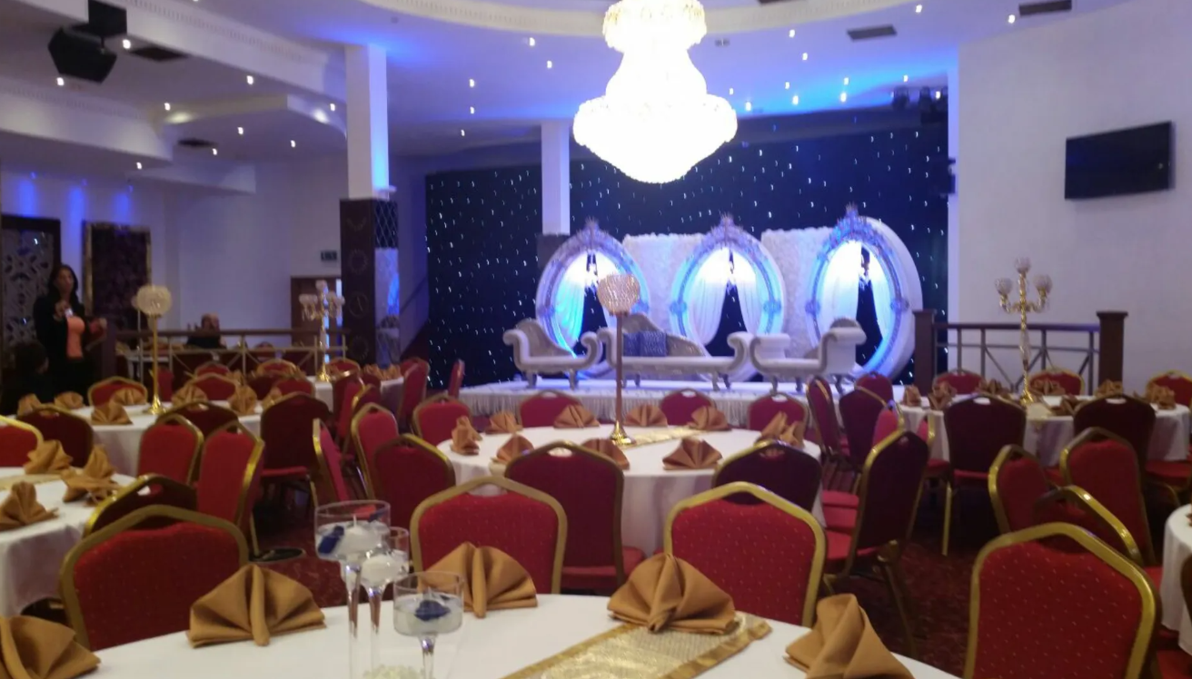 Elegant corporate event setup with round tables at The Grand Astoria venue.