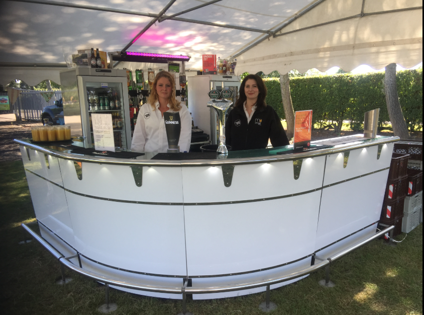 Sleek mobile bar setup for outdoor weddings and corporate events under a tent.