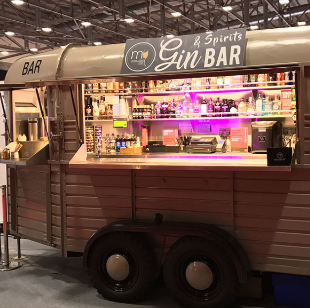 Sleek mobile gin bar with vibrant lighting for upscale events and gatherings.