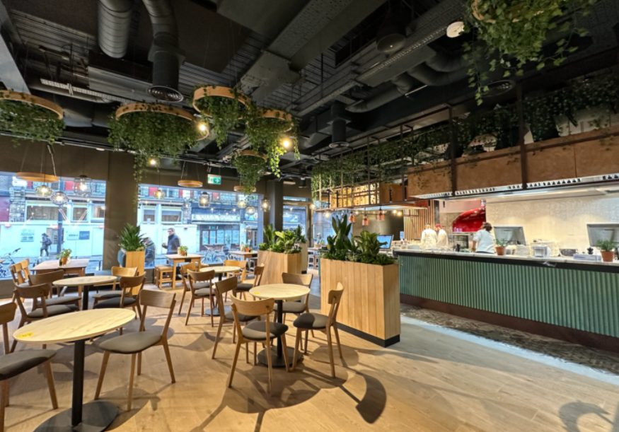 Modern café at Vapiano with greenery, ideal for casual meetings and networking events.