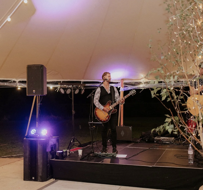 Live performance at Yuletide Bar with stylish musician, perfect for outdoor weddings.