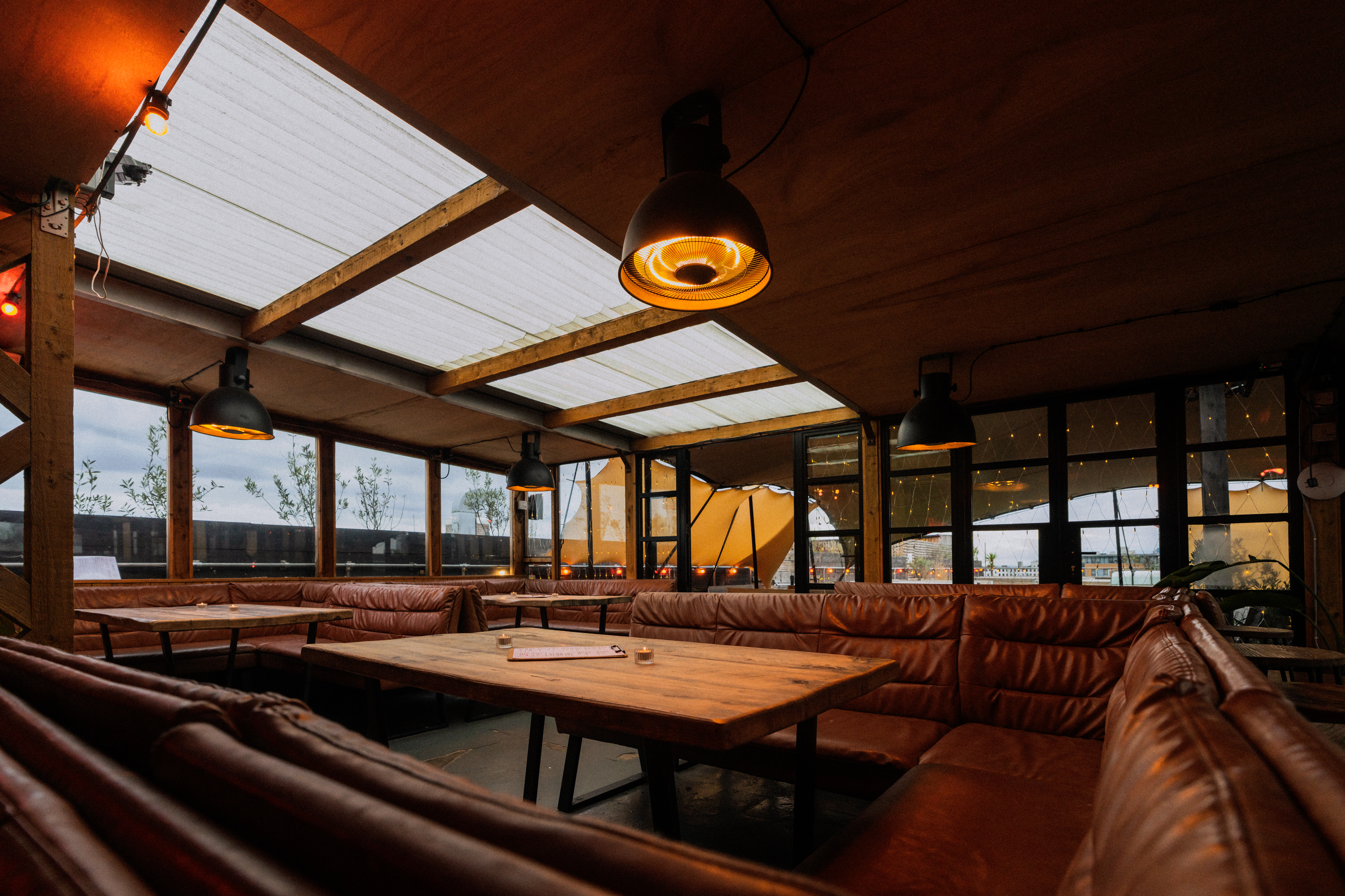 Modern event space at Netil360 Rooftop with leather seating and natural light. 