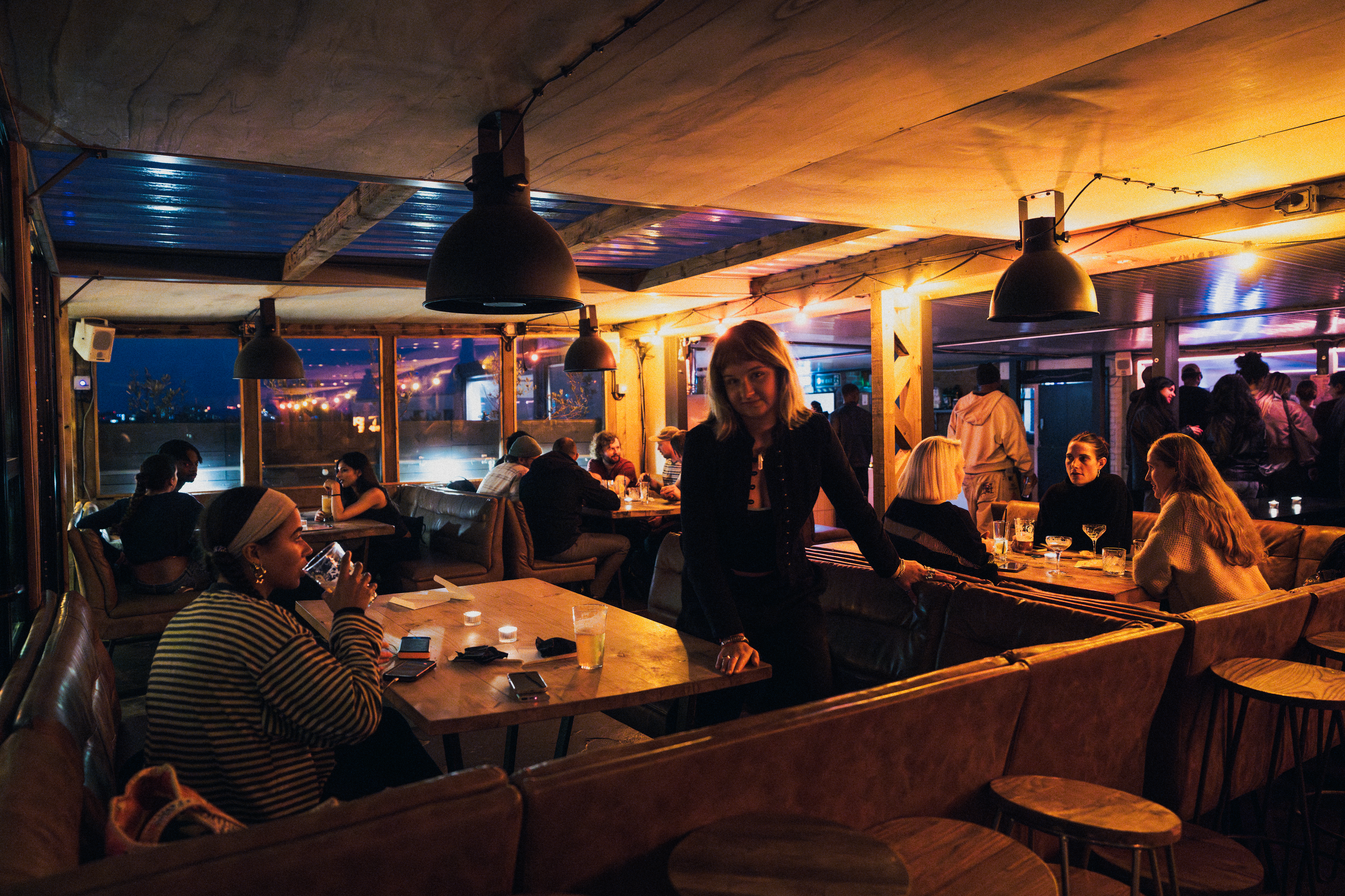 Cozy Netil360 Rooftop restaurant with warm lighting for gatherings and networking events.