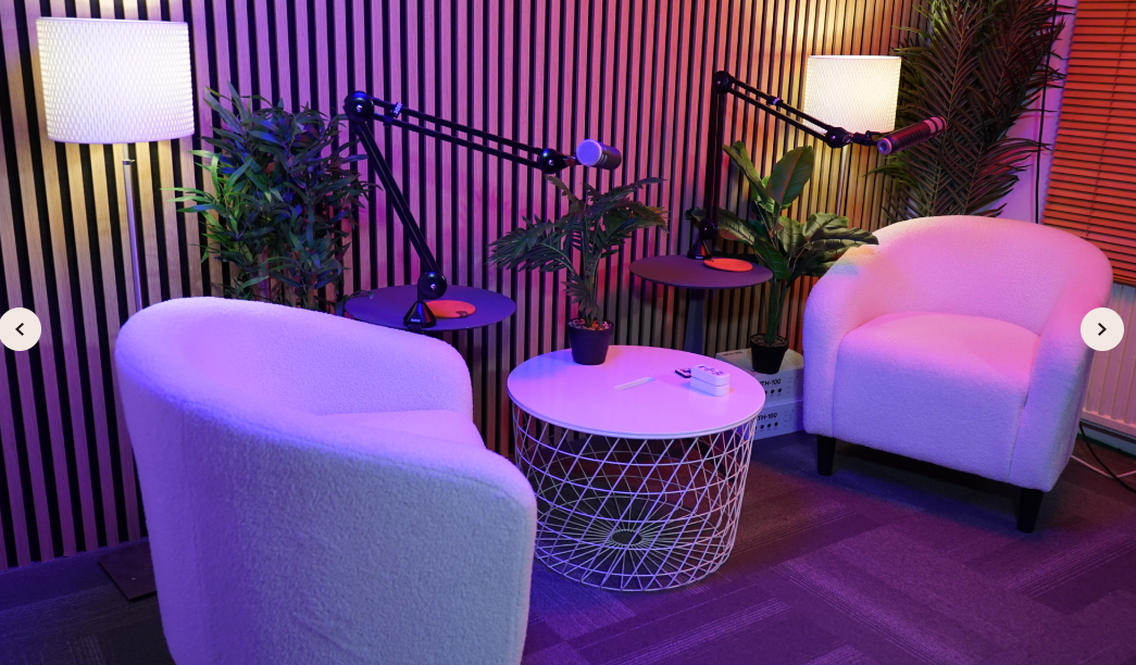 Modern podcast studio with cozy chairs and adjustable microphones for creative events.