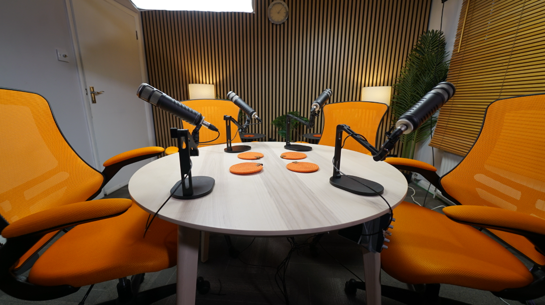 Modern podcast studio with round table, microphones, ideal for interviews and discussions.