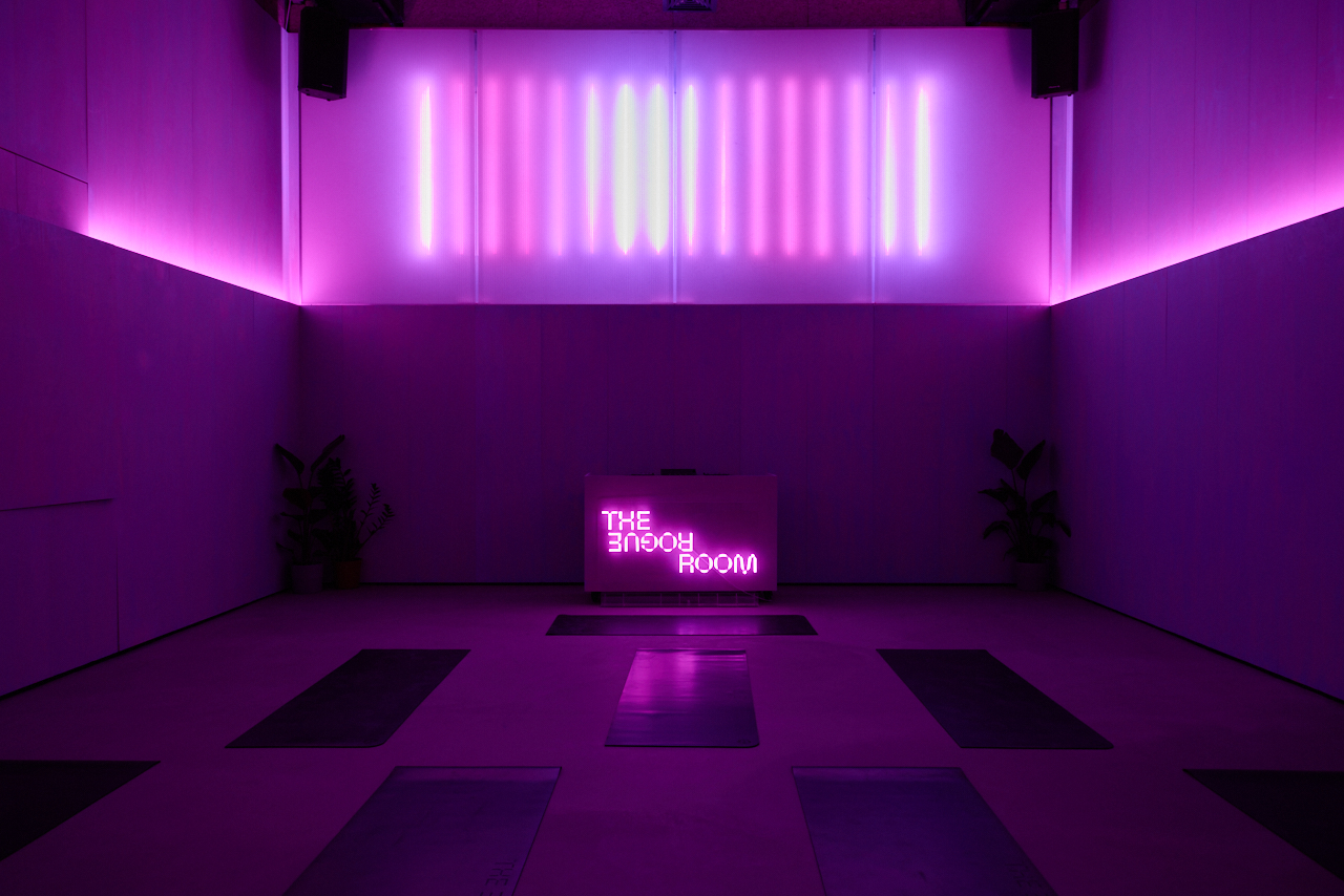 Modern immersive wellness event space at The Rogue Room with dramatic LED lighting.