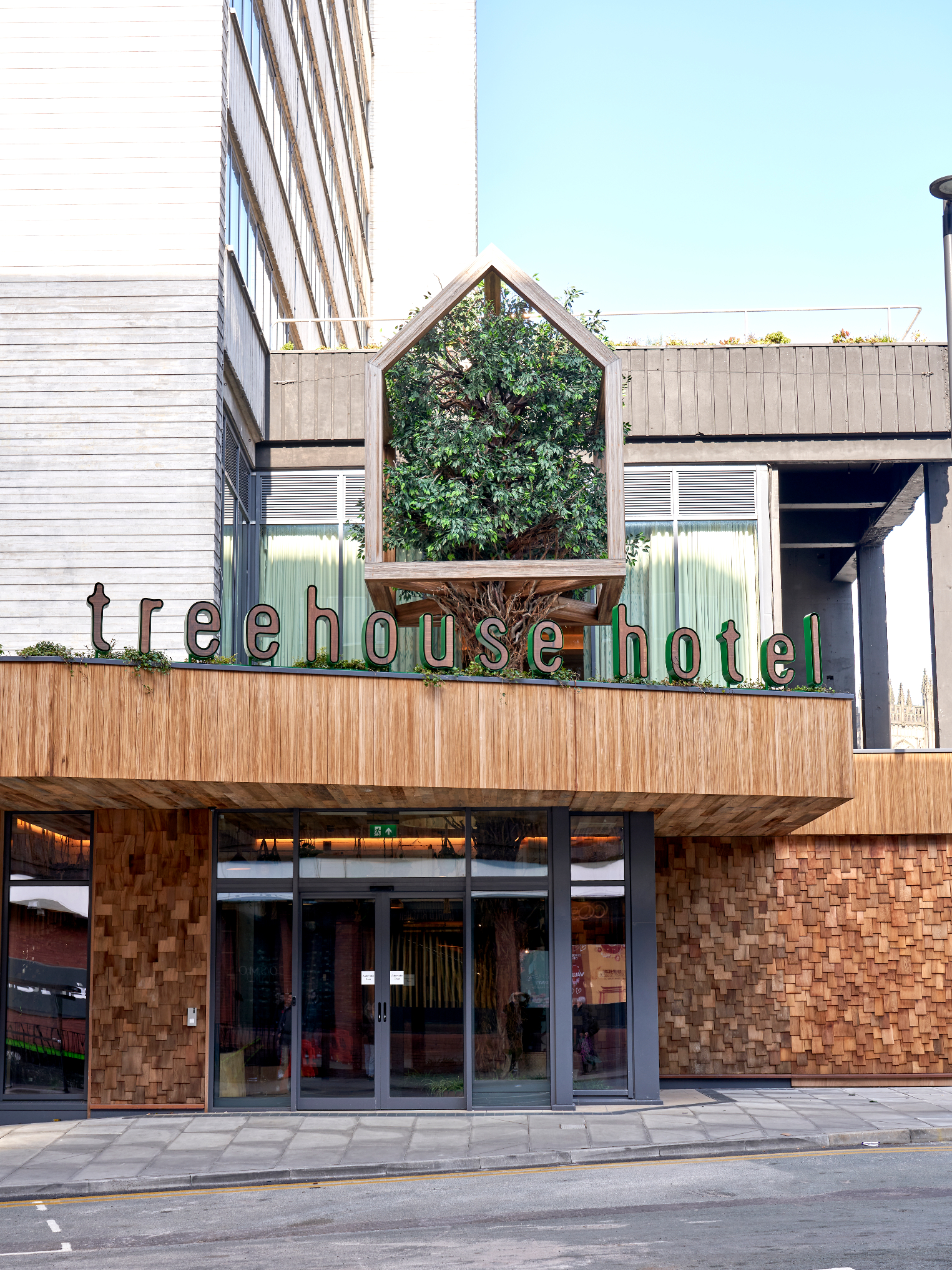 Pip at Treehouse Hotel Manchester entrance, perfect for corporate events and retreats.