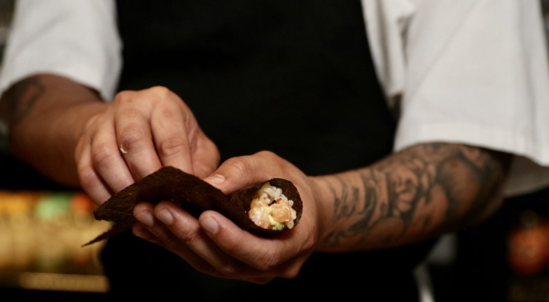 Chef preparing hand roll at Ukiyo Hand Roll Bar for quality catering at events.