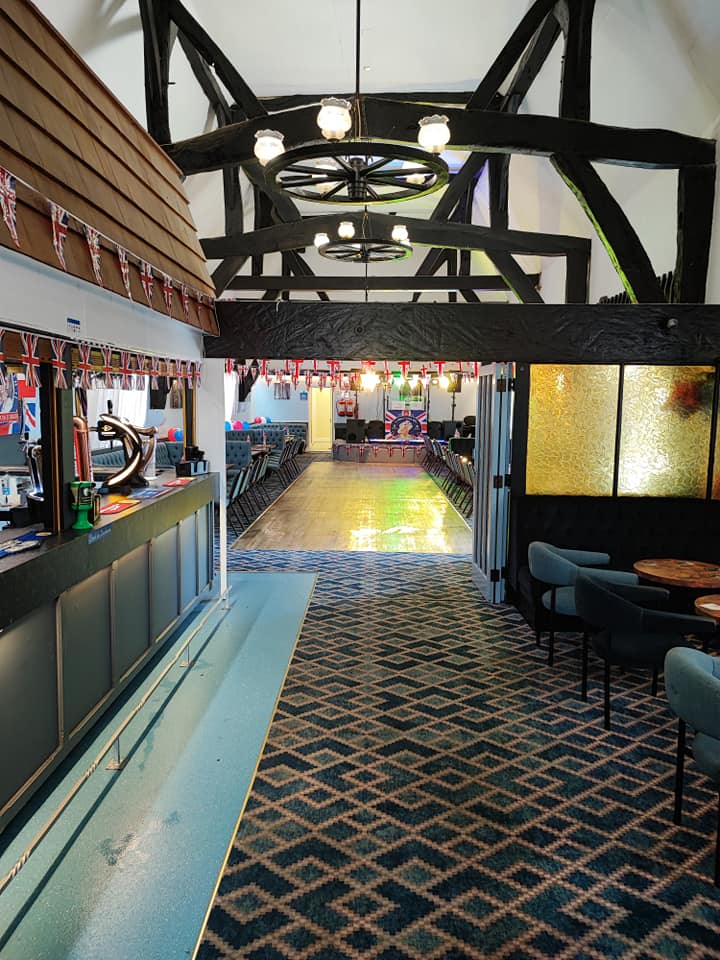 Tythe Barn event space with colorful lighting, ideal for weddings and gatherings.