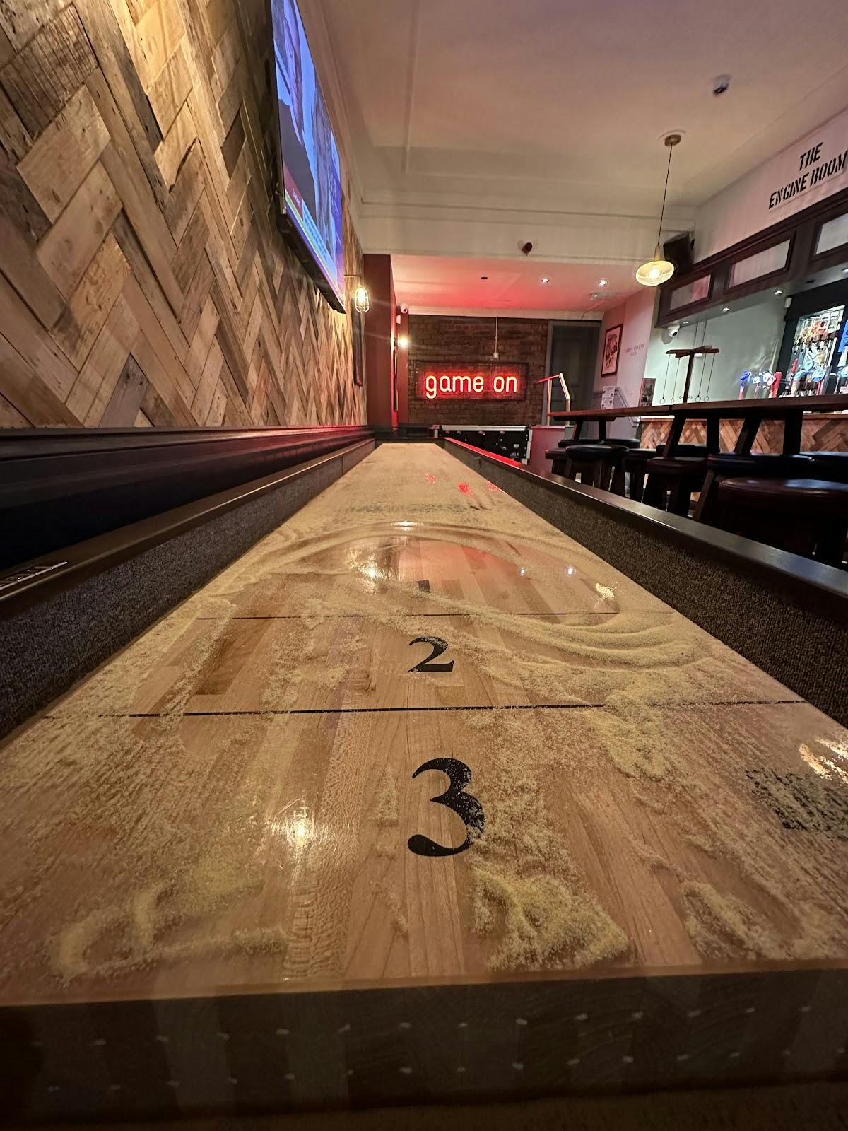 Shuffleboard table in The Hoptimist, ideal for corporate events and social gatherings.