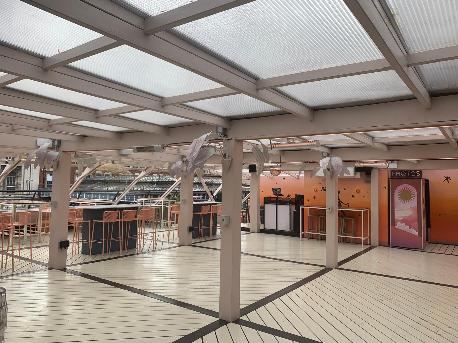 Modern rooftop event space with wooden deck for corporate events and celebrations.