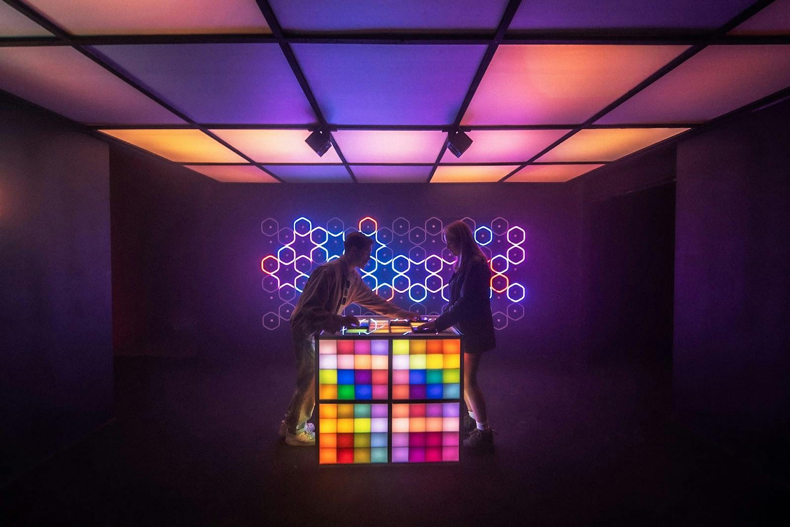 Rooftop bar in SUPERMASSIVE with illuminated DJ booth for vibrant networking events.