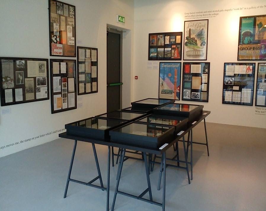 Modern NICOLA Arts studio with sleek glass tables for exhibitions and networking events.