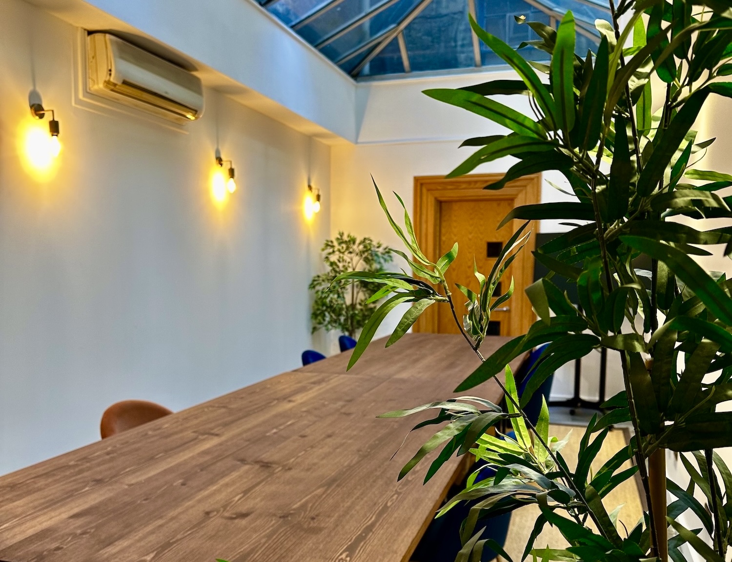 Sleek meeting space at Starstruck HQ for collaborative events with greenery and wooden table.
