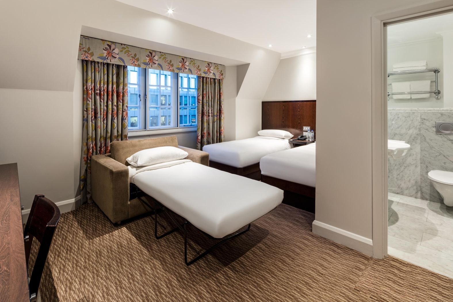 Modern guestroom at Radisson Blu Hotel with two beds, ideal for conferences and workshops.