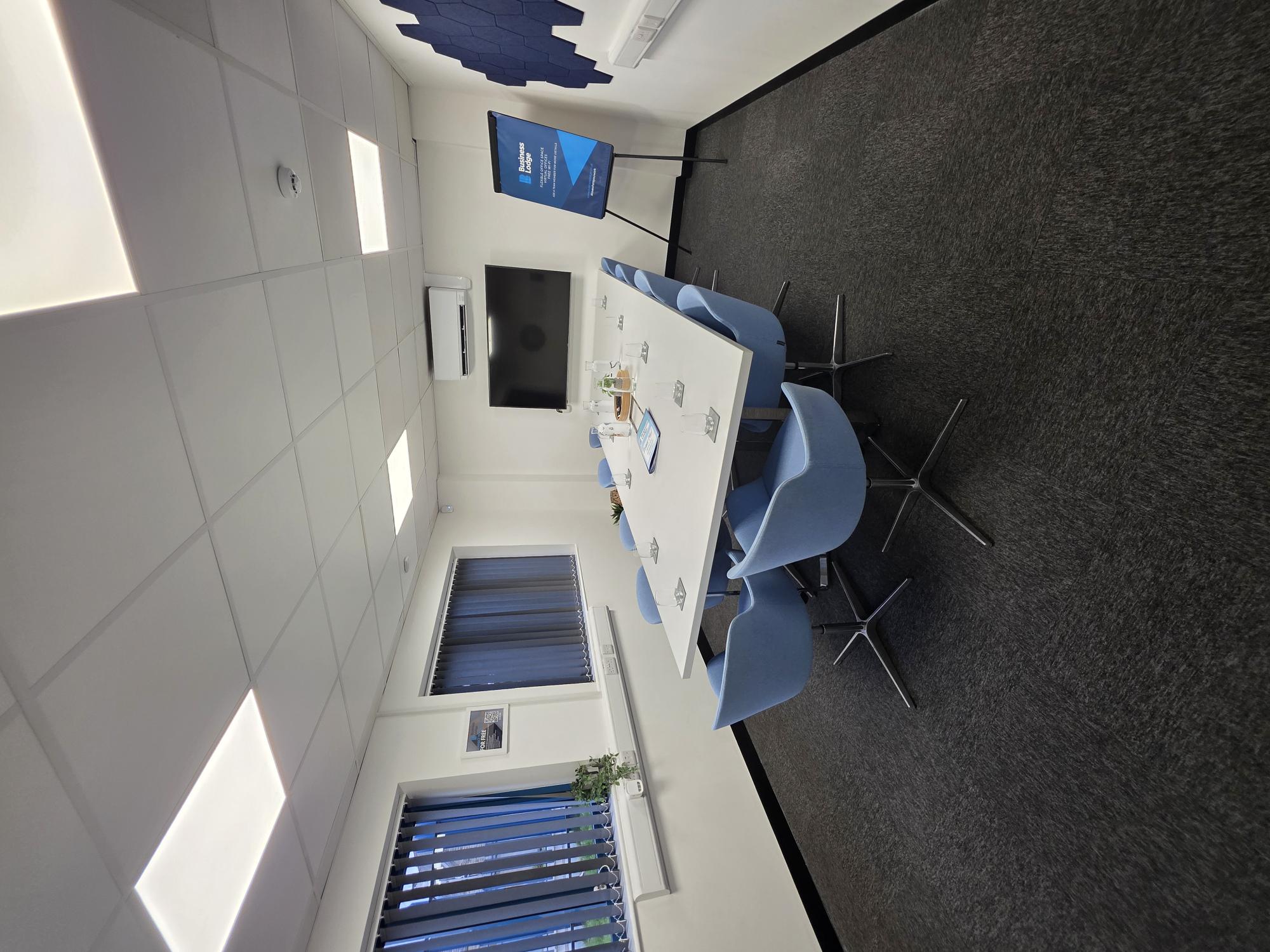 Modern meeting room with blue chairs, ideal for corporate events and workshops.