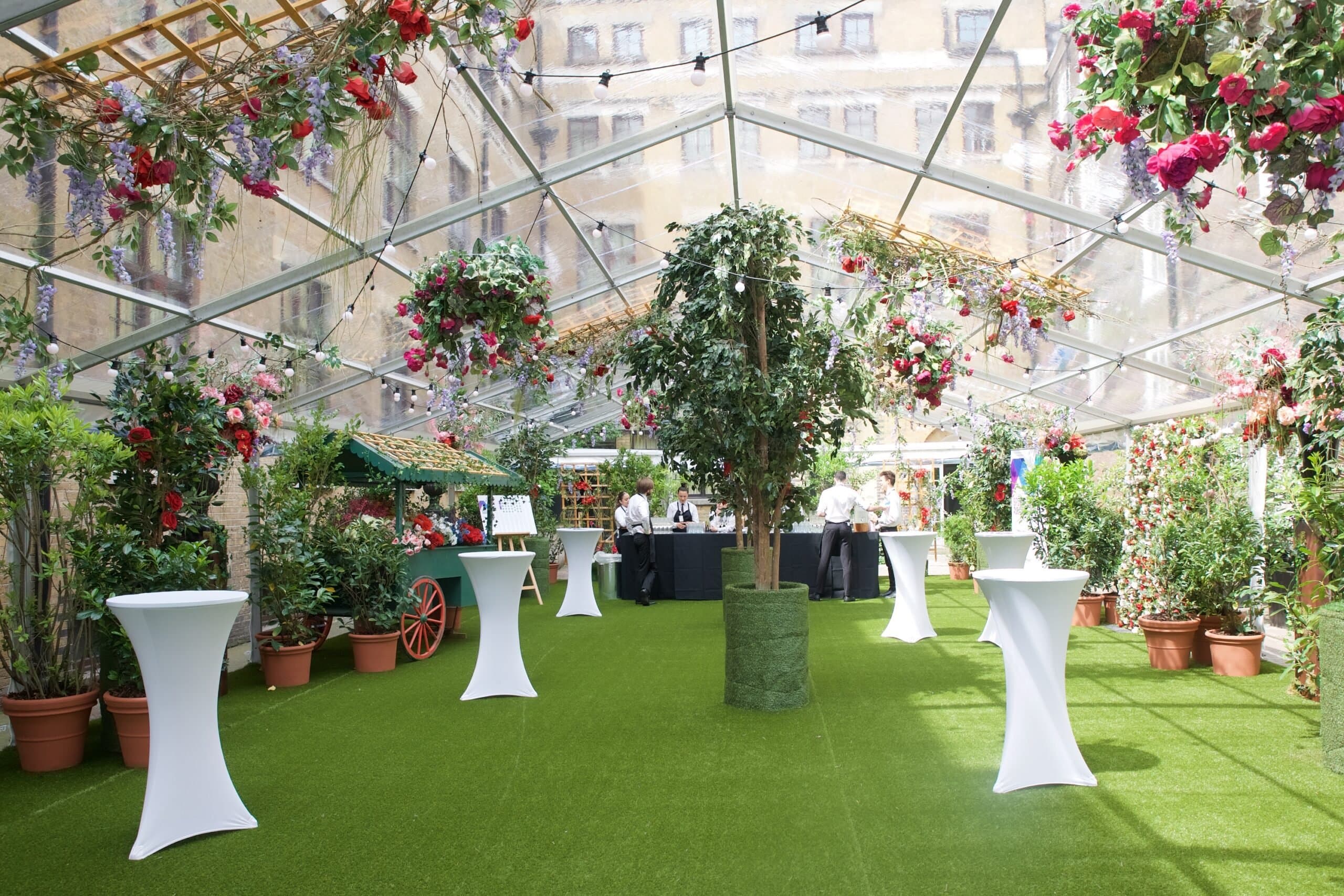 Outdoor event space with clear tent and vibrant flowers for cocktail receptions.