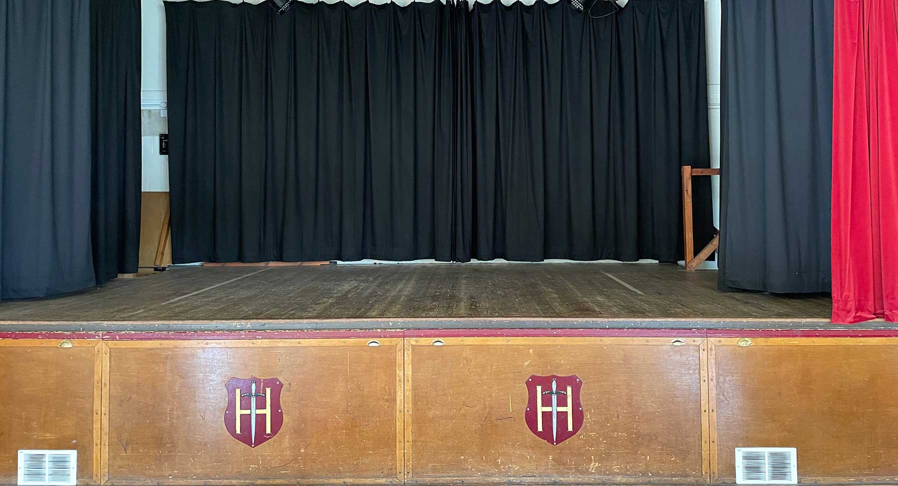 Main Hall stage setup with black curtains in Holyport Memorial Hall for events.