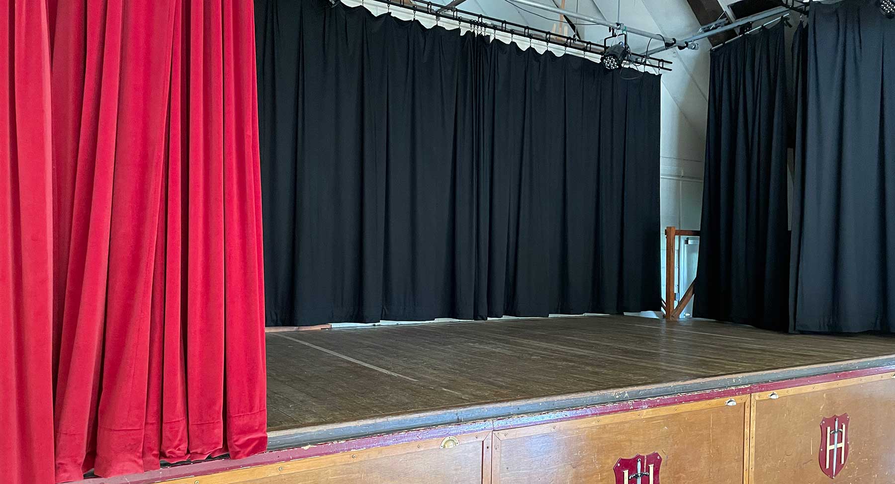 Main Hall at Holyport Memorial Hall with elegant red stage curtains, ideal for events.