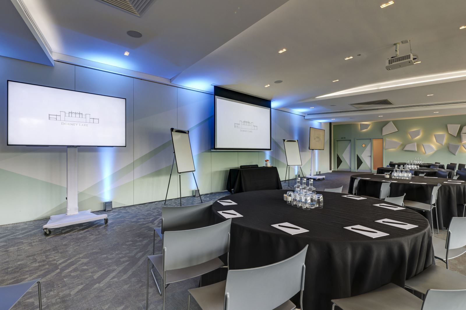 Modern Dorney Village Hall event space with round tables for meetings and presentations.