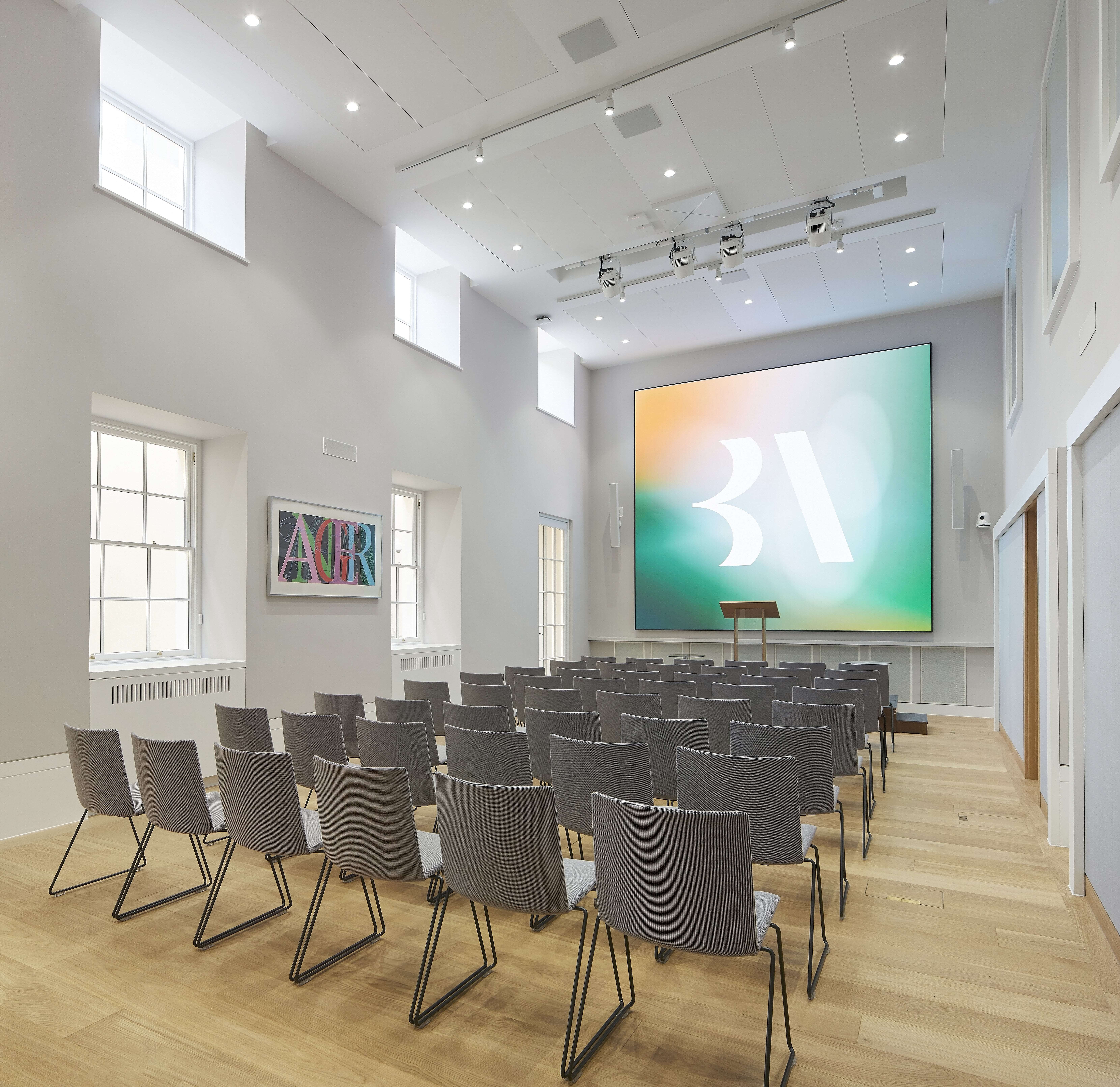 Modern lecture room with spacious layout and digital screen for presentations and workshops.