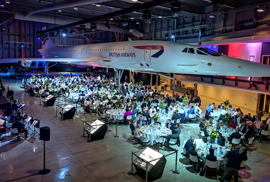 Elegant gala dinner under vintage Concorde aircraft at Aerospace Bristol.