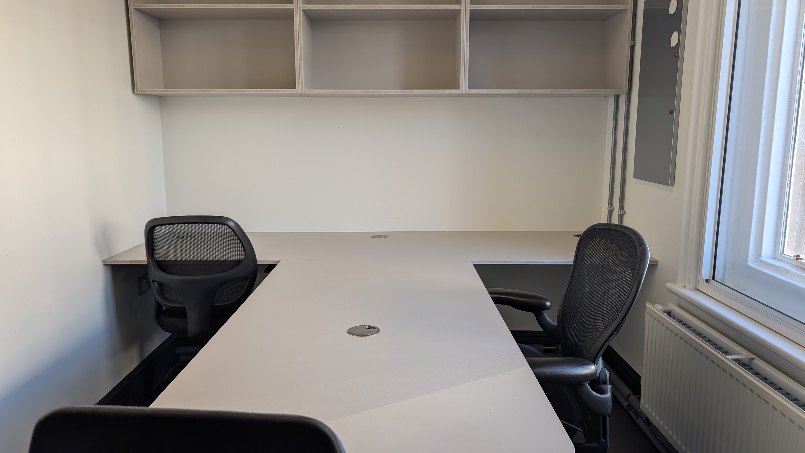 Minimalist meeting room at Bush Theatre, spacious table & ergonomic chairs for team sessions.