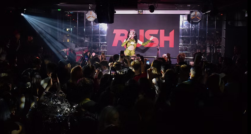 Live performance at Rush nightclub with dynamic stage lighting and LED backdrop for events.