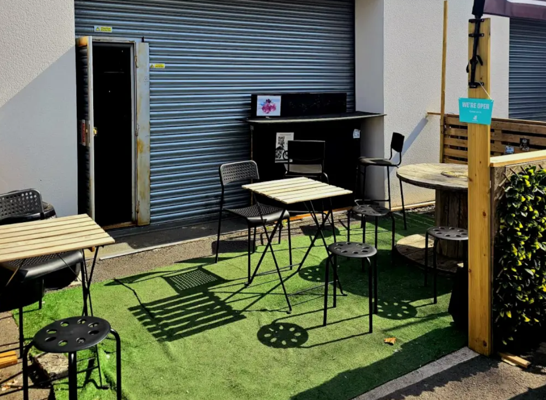 Explorers Hangout: Outdoor event space with minimalist furniture for casual gatherings.