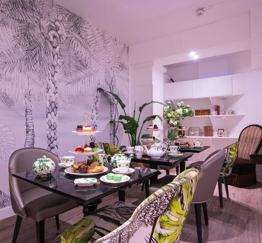 Elegant afternoon tea setup at Brigit's Bakery Covent Garden with fine china and tropical decor.