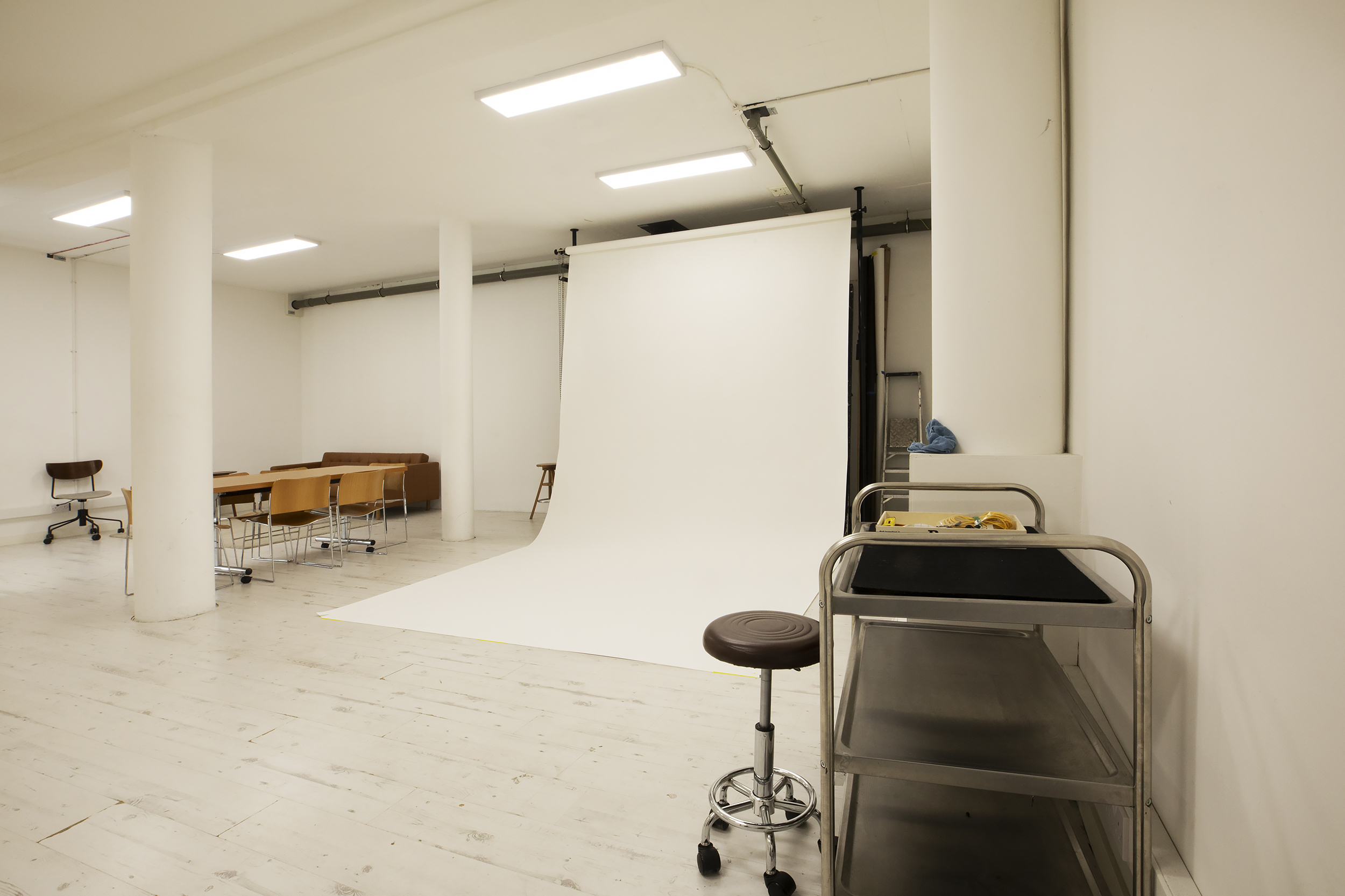 Deep Space 02: minimalist event space with white backdrop for presentations and workshops.