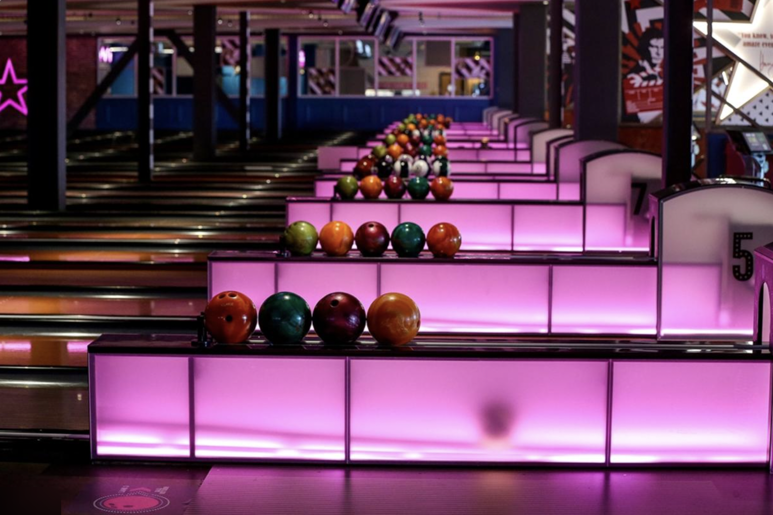 Vibrant bowling alley at Hollywood Bowl with illuminated lanes for events and team-building.