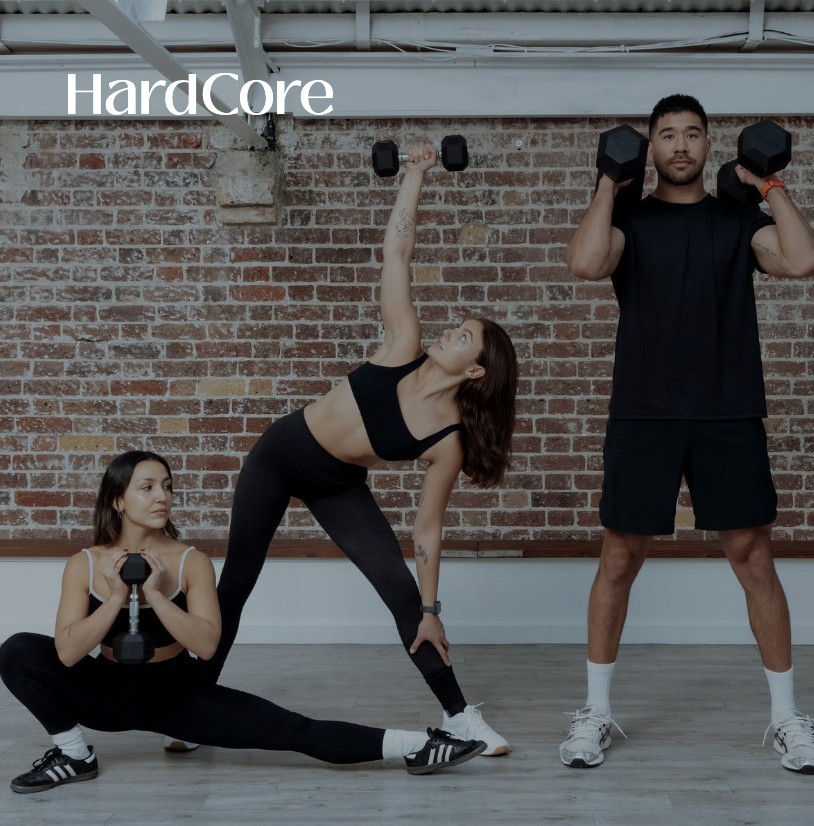 Dynamic fitness class with engaged participants using weights in an industrial-chic studio.