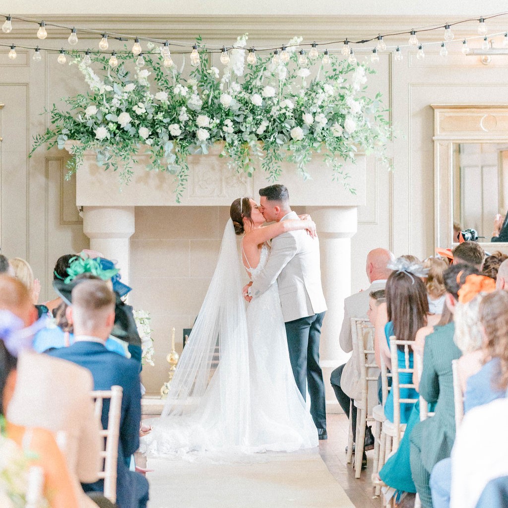 Elegant wedding ceremony at House & Enchanted Chapel with floral arrangement in Newton Hall.