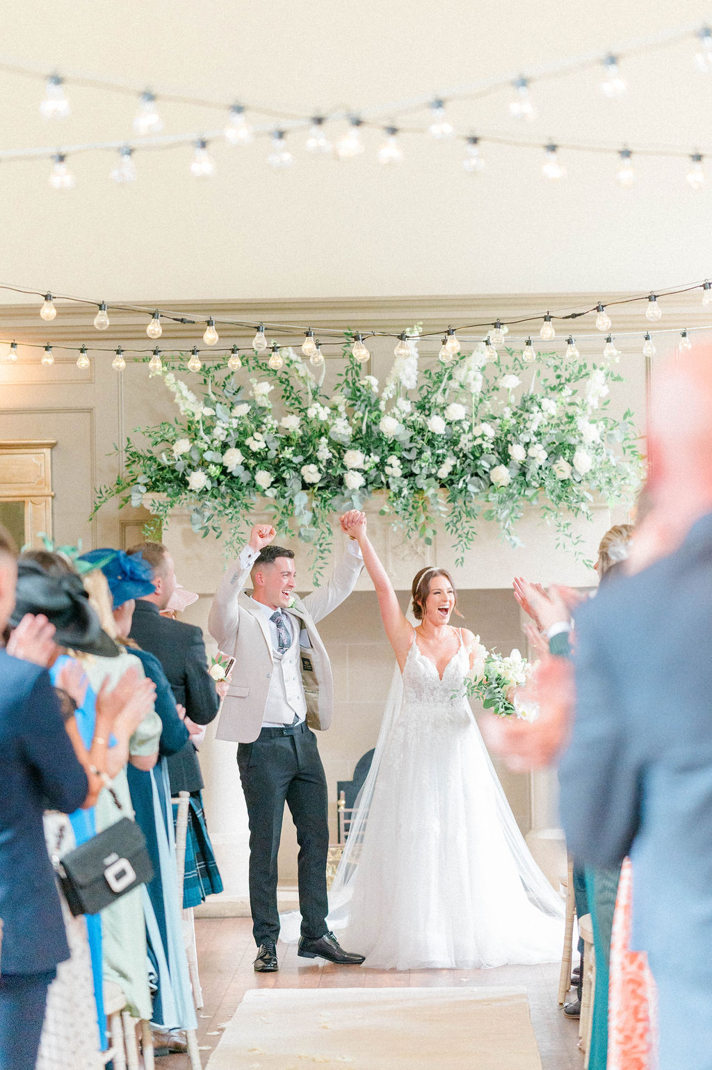 Joyful wedding couple at Enchanted Chapel, radiating love in elegant floral decor.