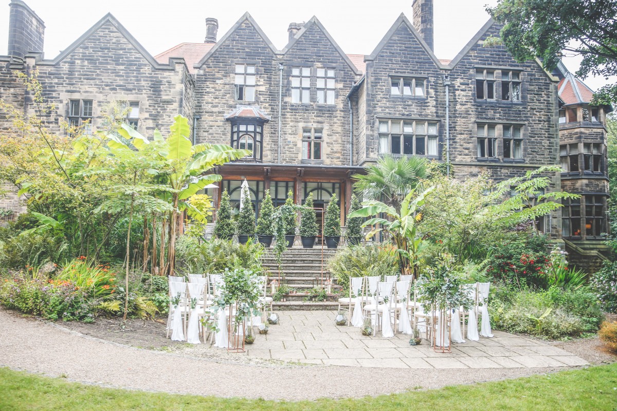 Charming outdoor wedding venue with historical building and lush greenery at The Mansion House.