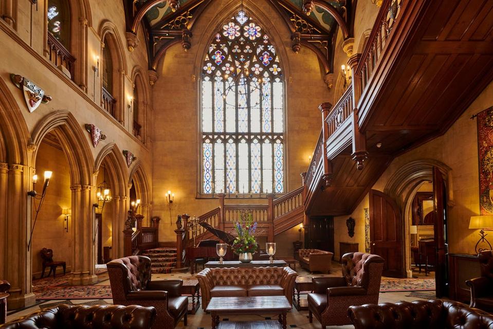 Elegant Great Hall in Matfen Hall, featuring grand staircase and stained glass for events.