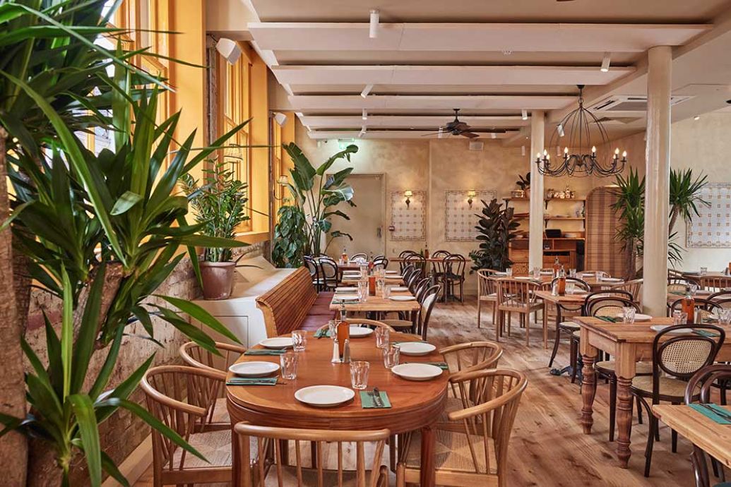 "Garden Side restaurant hire: cozy event space with wooden furniture and greenery."