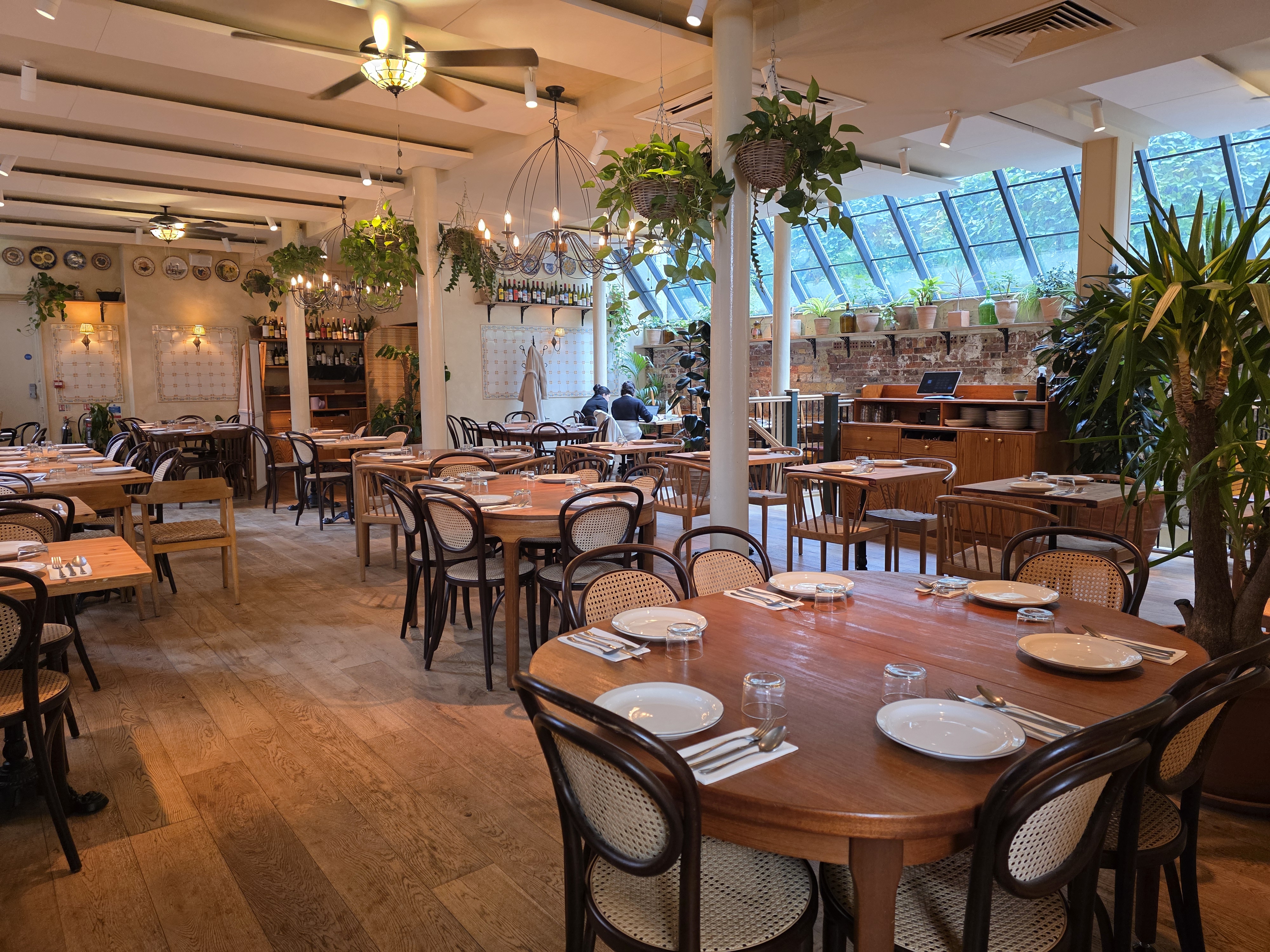 "Garden Side venue with wooden tables, perfect for intimate meetings and events."