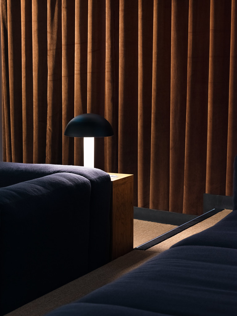 Cozy auditorium with plush seating and warm lighting for meetings and brainstorming sessions.