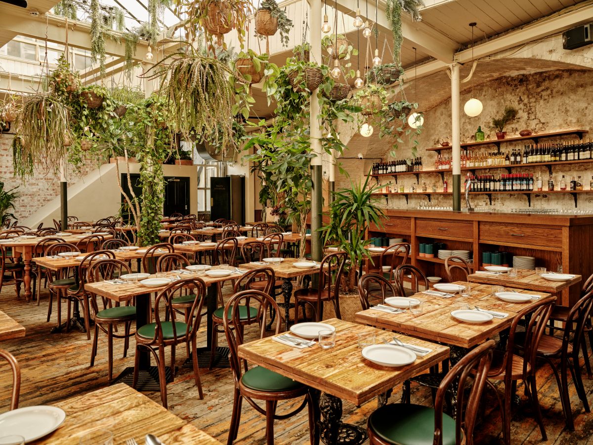 “Casa do Frango event venue with wooden tables, ideal for intimate gatherings and workshops.”