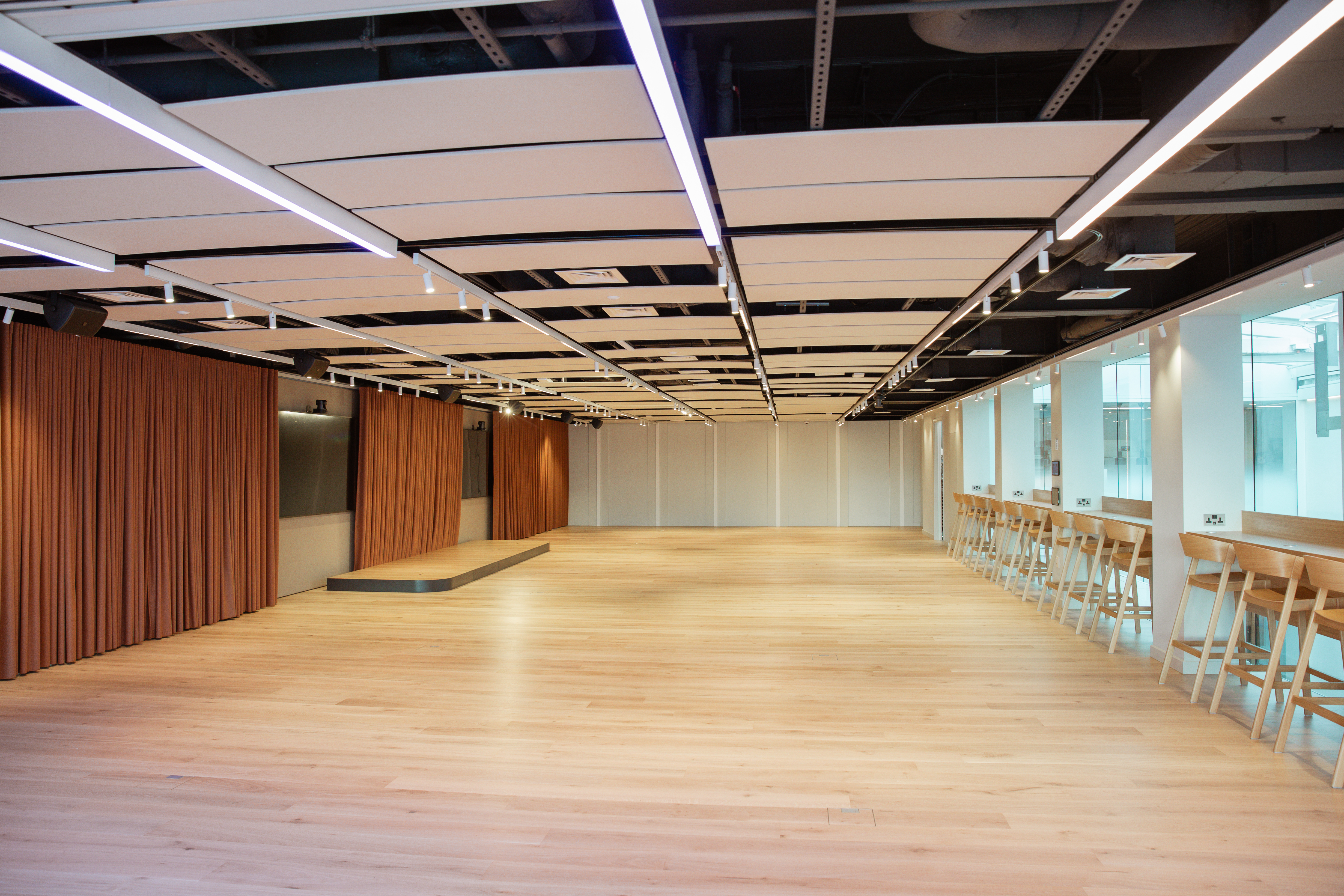 Spacious event space with wooden flooring, ideal for meetings and workshops at The View in 58VE.