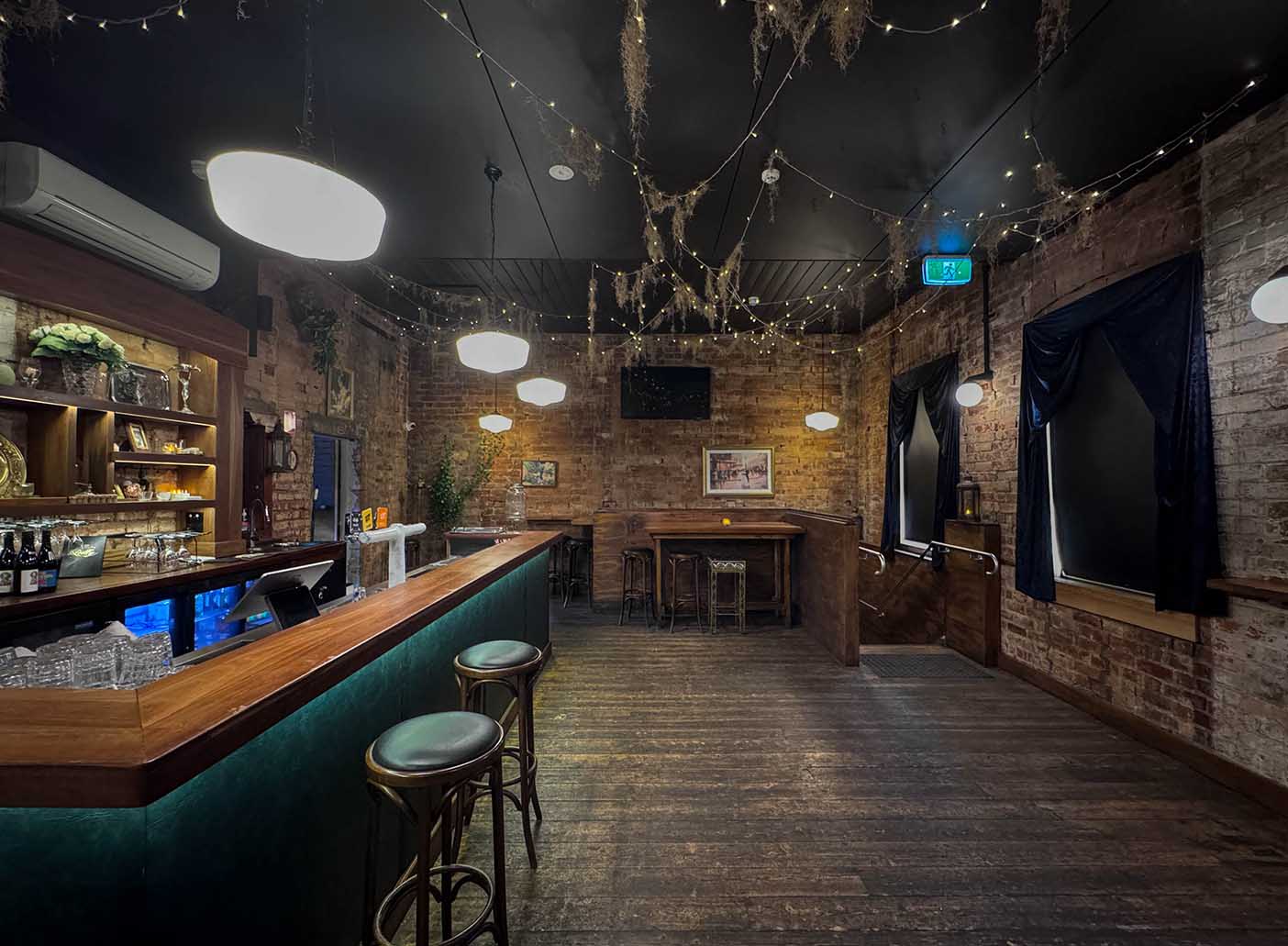 Cozy Private Function Room at Polly Bar with exposed brick, perfect for cocktail events.