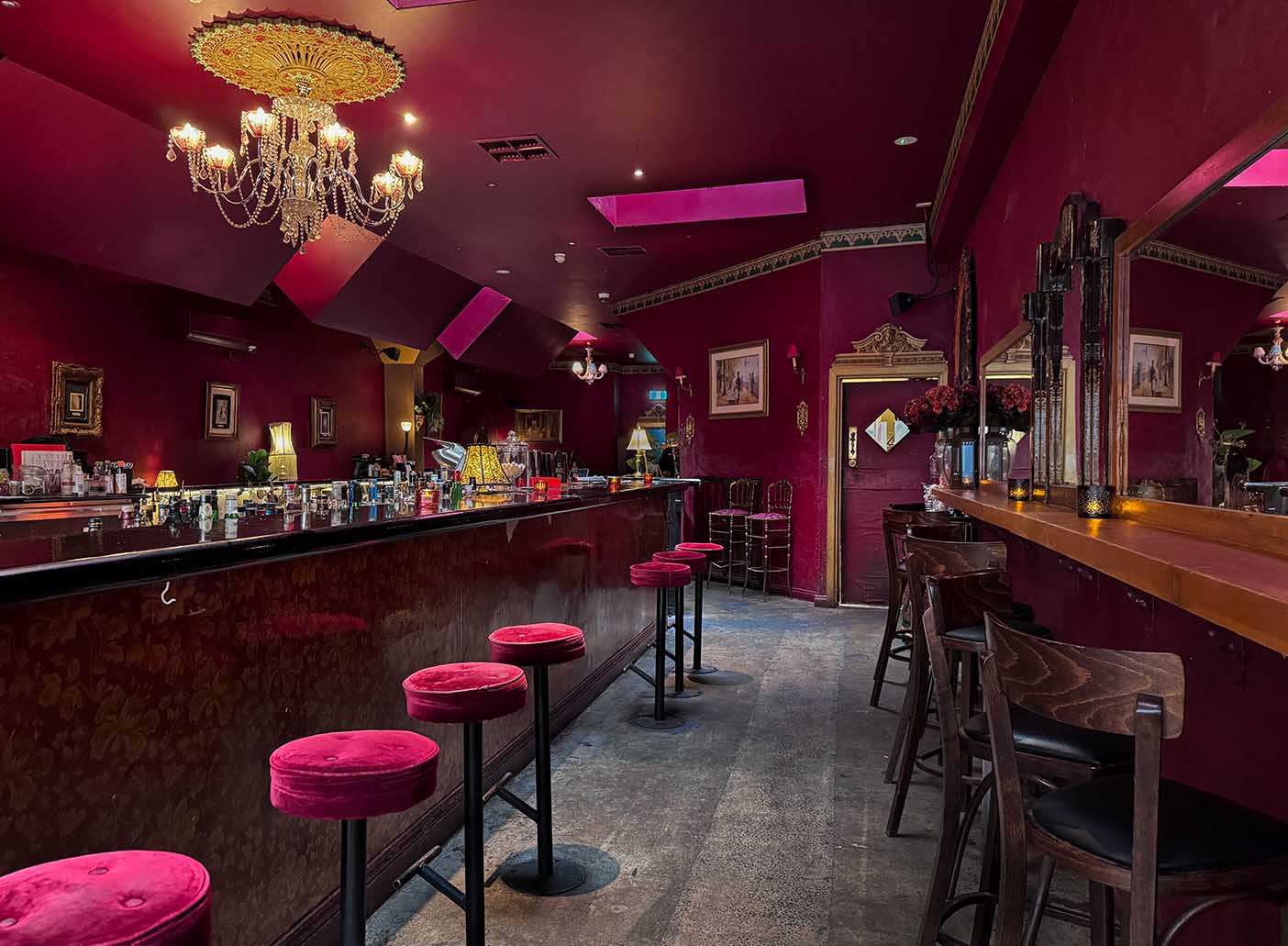 Chic private function room at Polly Bar with burgundy walls, ideal for upscale events.